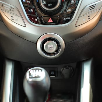 Modern car interior with engine start stop button in focus.