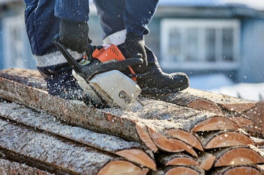 Sawing wood with a chainsaw for the furnace furnace in the fresh air. High quality photo