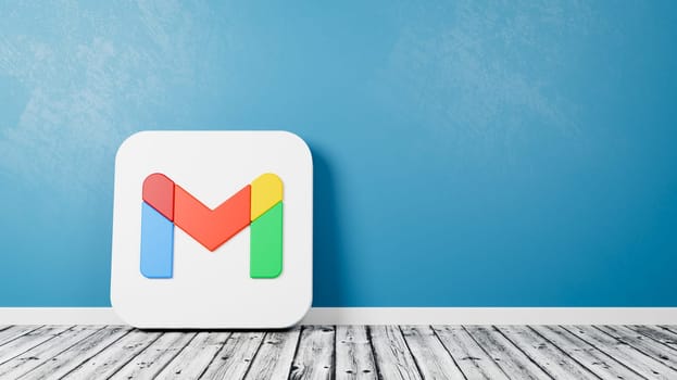 Gmail App Icon 3D Symbol Shape on Wooden Floor Against Blue Wall with Copy Space 3D Render Illustration