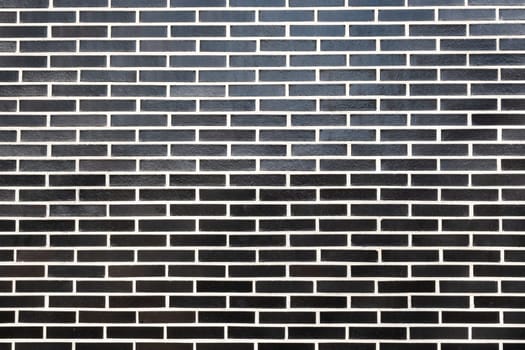 A black brick wall texture with white grout, horizontal orientation. Great seamless background for different purposes, copy space for text.