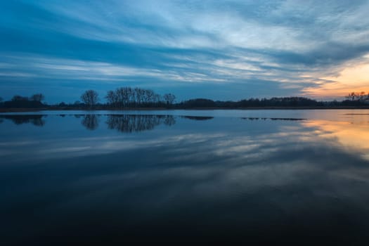 Reflection of the evening clouds in a calm lake, Stankow, Lubelskie, Poland