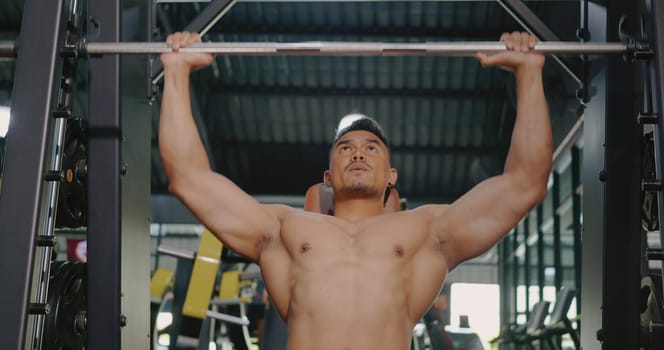 Muscular man working out exercise for triceps push down weightlifting with pull machine to flexing muscles at fitness gym, Sport fit workout bodybuilding concept