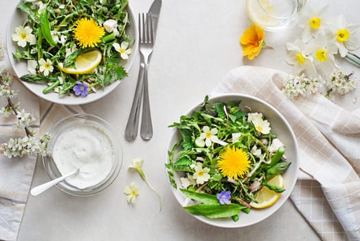 Spring salad with dandelion, asparagus, flowers, nettle and cream cheese. Healthy spring detox food ingredients.