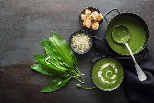 Fresh cream wild garlic soup on grey background overhead shoot