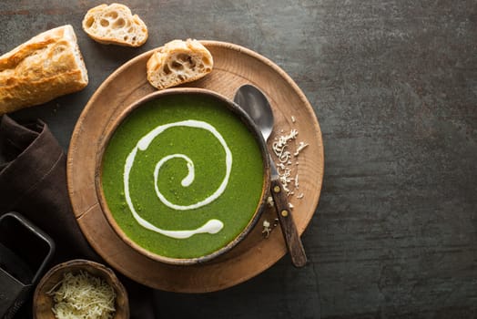 Fresh green soup on grey background overhead shoot.