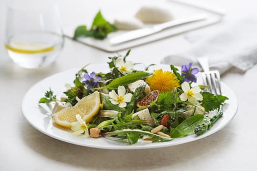 Spring salad with dandelion, asparagus, wild garlic, flowers, nettle and cream cheese. Healthy spring detox food ingredients.