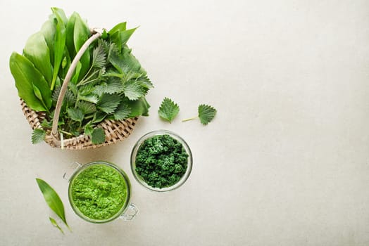 Spring healthy food. Nettle and ramson pesto for healthy meal on grey background