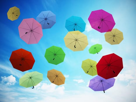 Multi colored umbrellas against blue sky. 3D illustration.