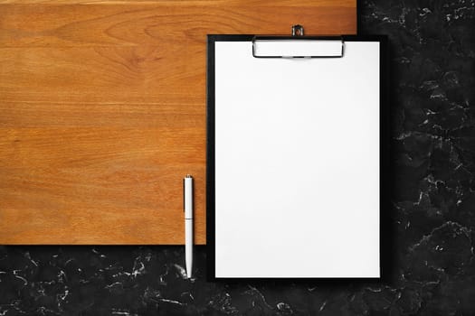 Clipboard, blank letterhead and pen. Photo of blank stationery set on wooden board background. Flat lay.