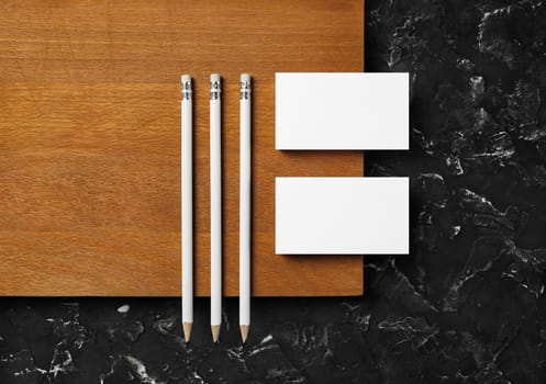 Brand identity mockup. Blank business cards and pencils on wooden board background. Flat lay.