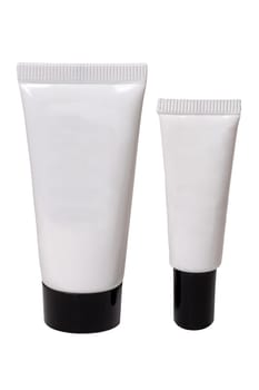 Containers for beauty products. Close-up of two white cosmetic tubes of different sizes with black caps. Skin care product or other products with space for your label isolated on a white background. Macro.