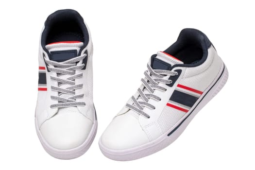 White sneakers isolated. Close-up of a pair white elegant stylish leather sport shoes isolated on a white background. Clipping path. Kids shoe fashion. Modern design footwear for workout. Macro.