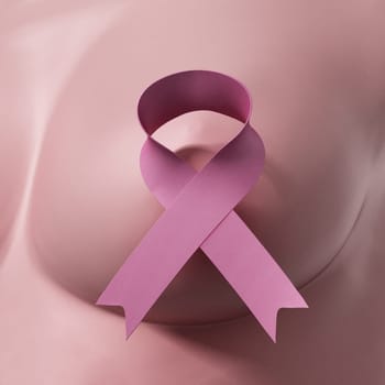 Pink cancer awareness ribbon on woman breast. 3D illustration.