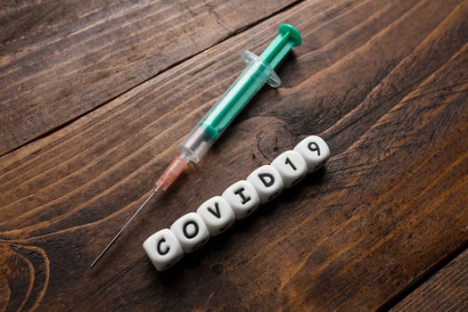 Corona virus Covid-19 vaccine text on wooden background