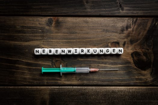 Corona virus Covid-19 vaccine text in German on wooden background