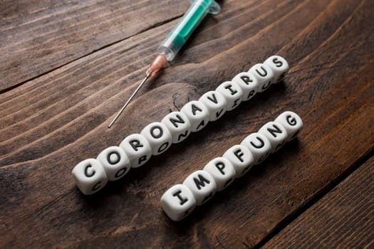 Corona virus Covid-19 vaccine text in German on wooden background