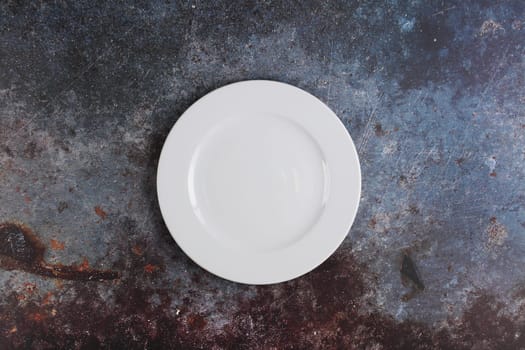 A white dinner plate on a marble surface