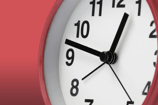 A clock face white with black hands on red background