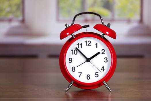 A traditional red alarm clock in room differential focus