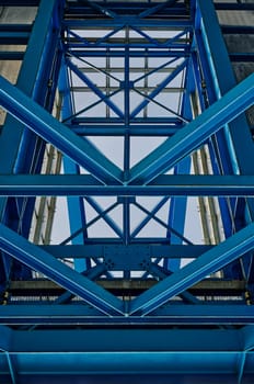 blue steel construction of a crane, blue steel braces, symmetrical structured, pattern, close-up view, worms-eye view