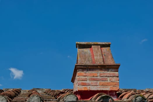 chimney on a tiled roof , blue cloudless sky