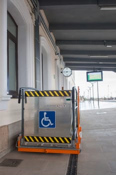 Special lift for wheelchairs at railway station. Assistance service for railway disabled passengers