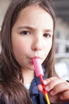 Little girl licking a whistle or melody pop. Selective focus