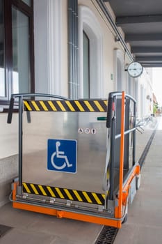 Special lift for wheelchairs at railway station. Assistance service for railway disabled passengers