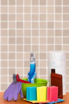 Spring cleaning background. Close-up of house cleaning products and cleaning supplies on orange wooden table over abstract bright background. Household chore concept. Macro.