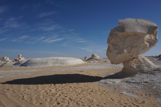 Long shadow of a head shaped rock formation in the white desert, Egypt