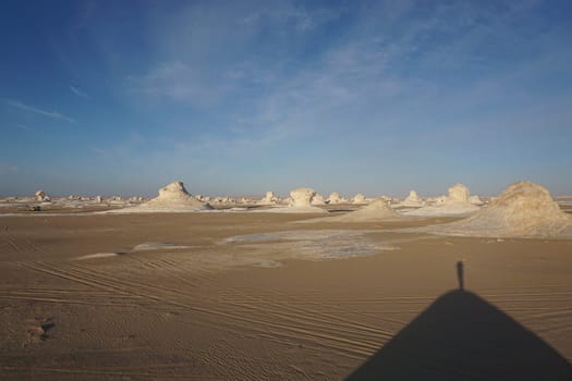 Small shade of a person on a hill in the white desert, Egypt