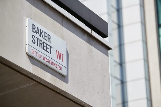 Detail of Baker Street sign on empty white building wall. Lots of copy space.