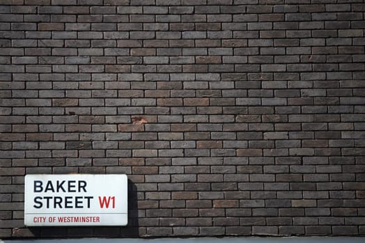 Dark brick wall with Baker Street sign at the bottom corner. Lots of copy space.