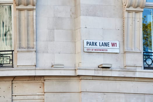 Detail of Park Lane street sign on empty building wall.