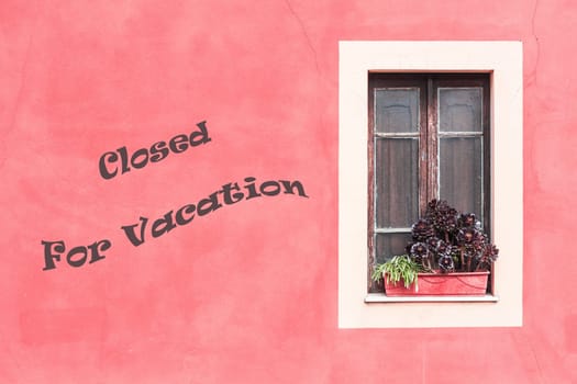 Closed window with planter  and red wall. Closed for vacation