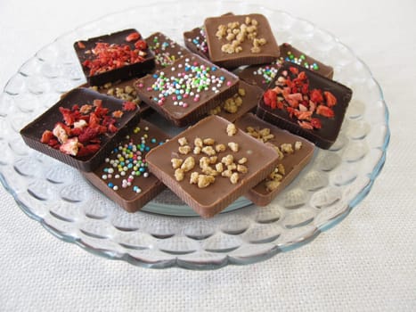 Various homemade chocolate pieces on a glass plate