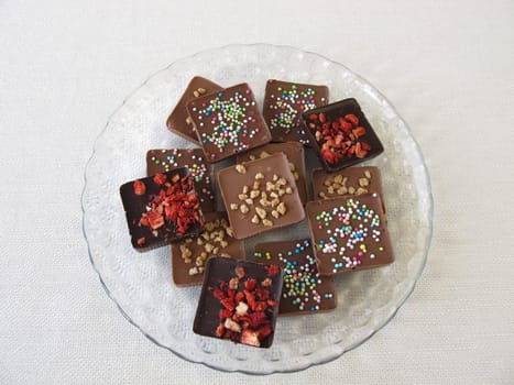 Various homemade chocolate pieces on a glass plate
