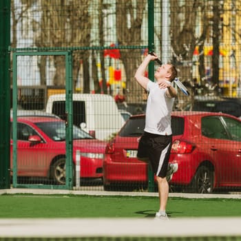 young man play tennis outdoor on tennis field at early morning