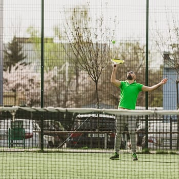 young man play tennis outdoor on tennis field at early morning