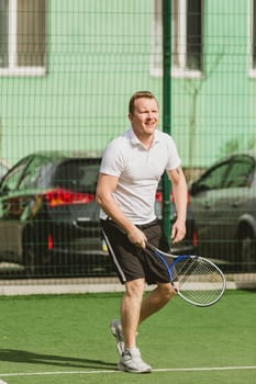 young man play tennis outdoor on tennis field at early morning