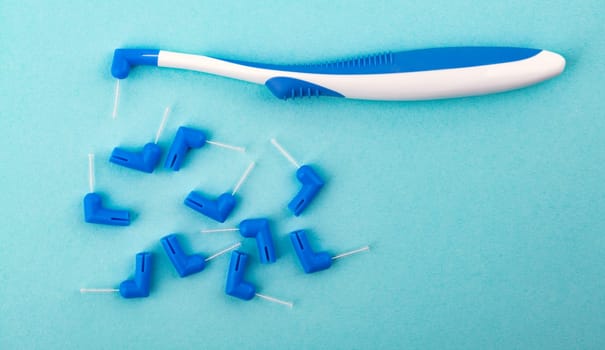 Concept interdental brush over light blue background