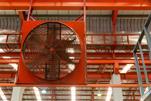 Big industrial cooler red fans in factory for reduced heat in operation ventilation of plant, industry cooling mechanical fan