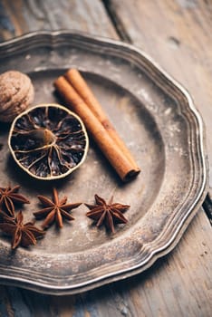 Aromatic spices in rustic silver plate. Winter christmas concept.