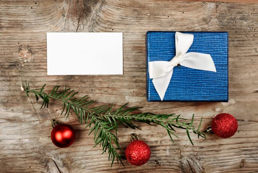 Christmas present and empty card on wooden table.