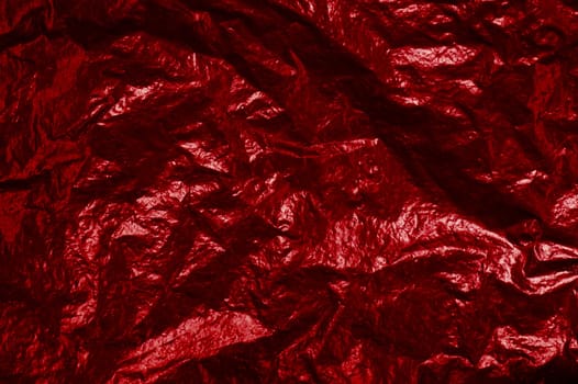 Background texture of red shiny foil with light reflection