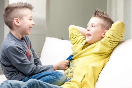 little brothers one in front of the other one smiling and laughing