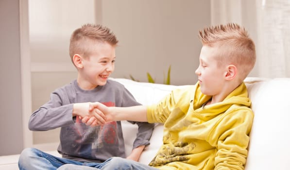 two kids shaking their hands as like as they were businessmen
