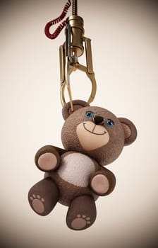 Toy claw machine holding a teddy bear. 3D illustration.