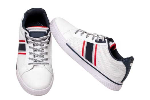White sneakers isolated. Close-up of a pair white elegant stylish leather sport shoes isolated on a white background. Clipping path. Kids shoe fashion. Modern design footwear for workout. Macro.