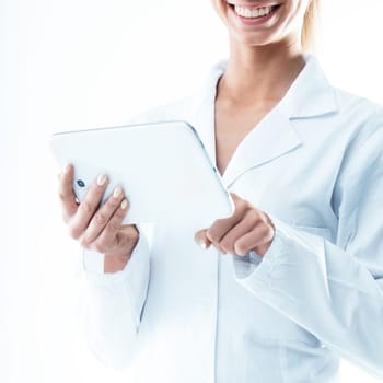 smiling doctor holding a digital tablet and tapping with her index finger